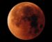 A full moon in the dark night sky tainted red as it is a full lunar eclipse called the blood moon, September in the UK